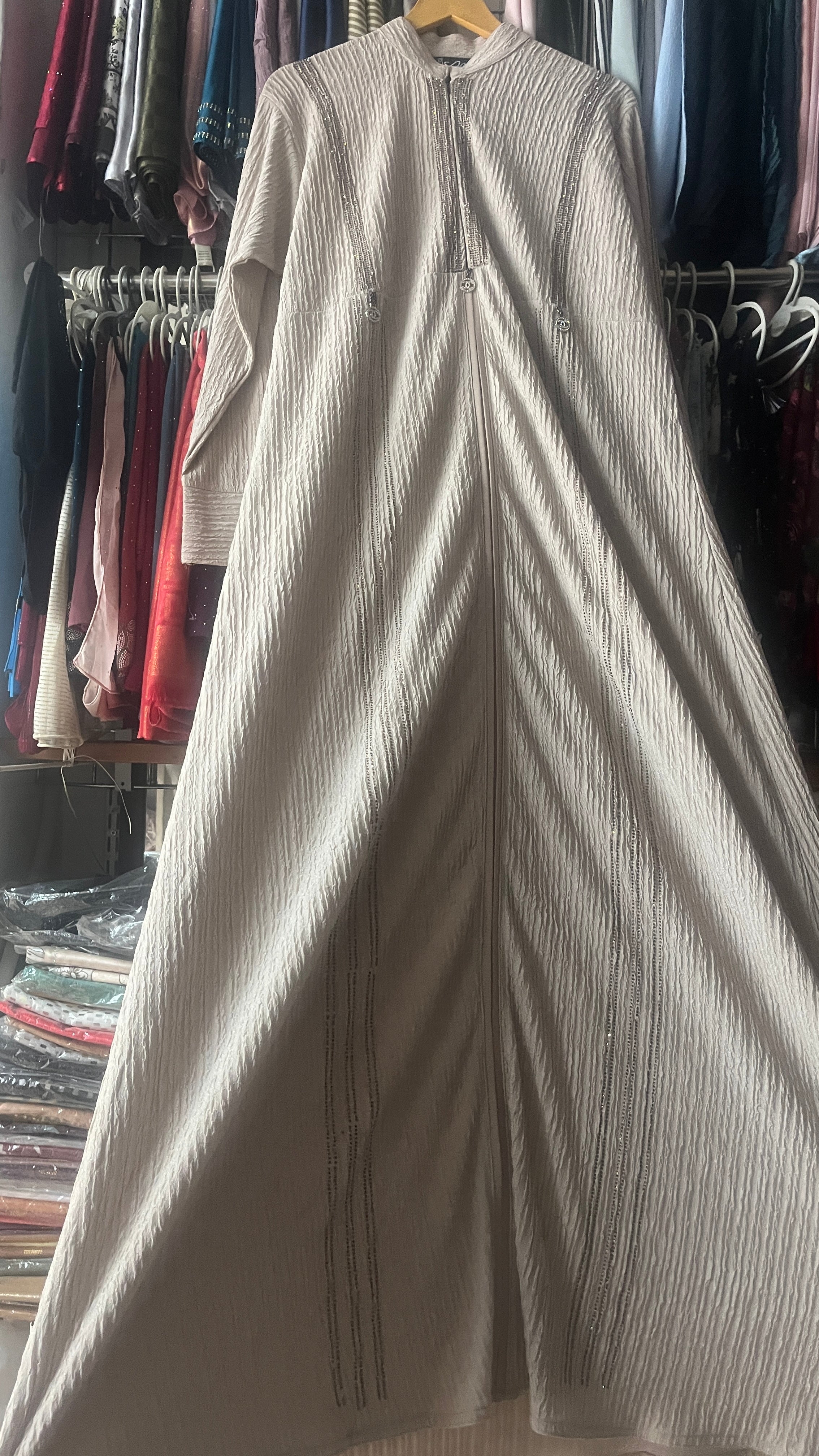 Beige ribbed rhinestone embellished abaya full length view on hanger