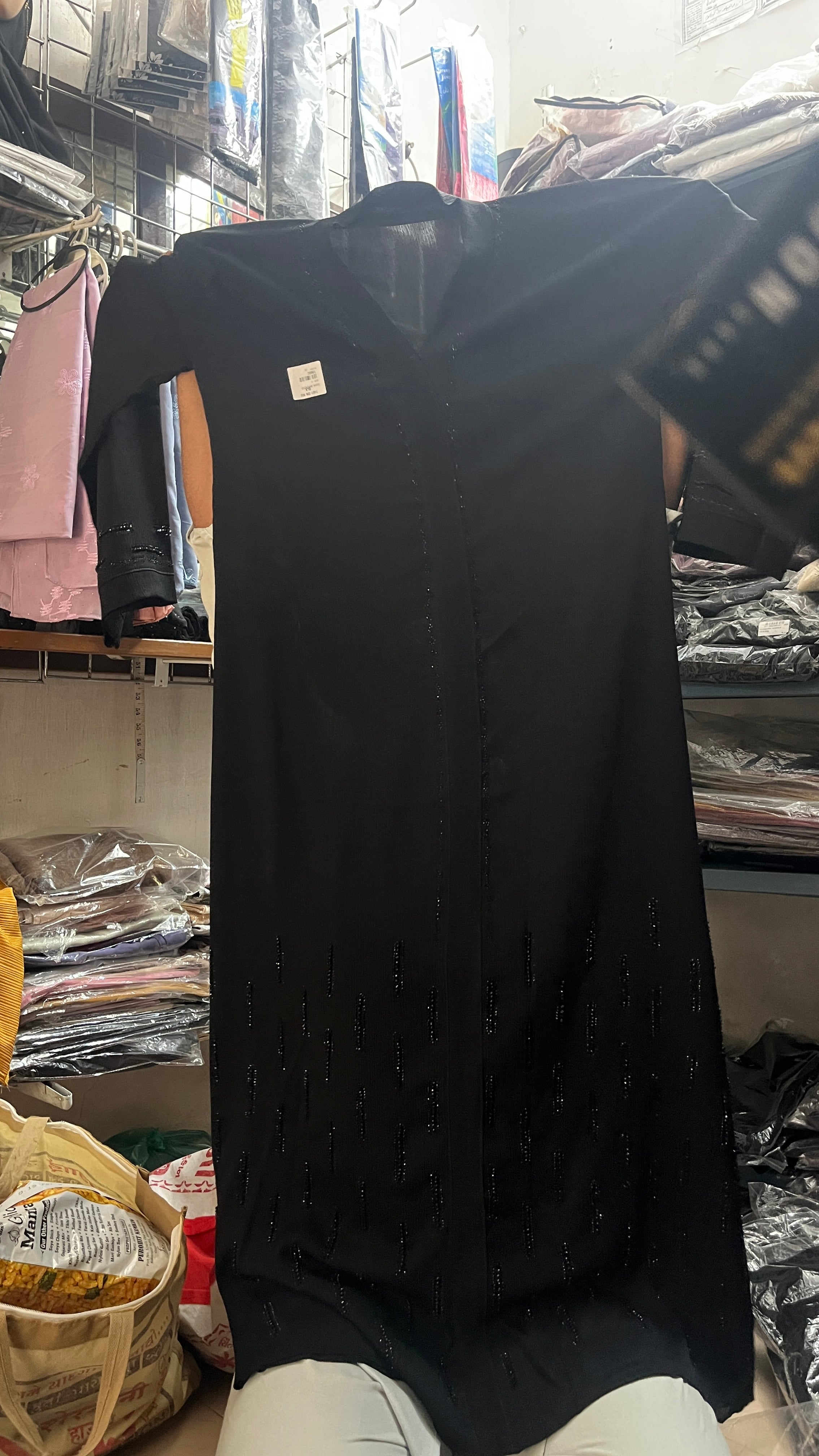 Close up beaded embellishment detail on black abaya hemline