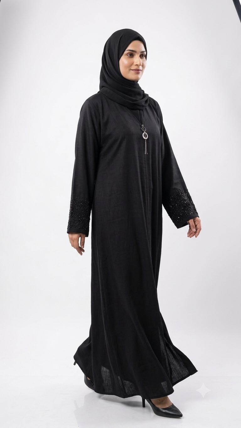 Woman wearing black abaya with beaded lace cuffs and pendant necklace, matching hijab, side view