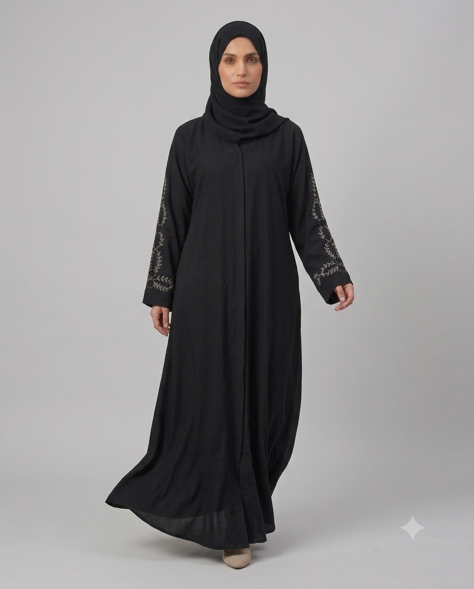Woman wearing black abaya with beaded rose vine sleeve embroidery and matching hijab, portrait front view