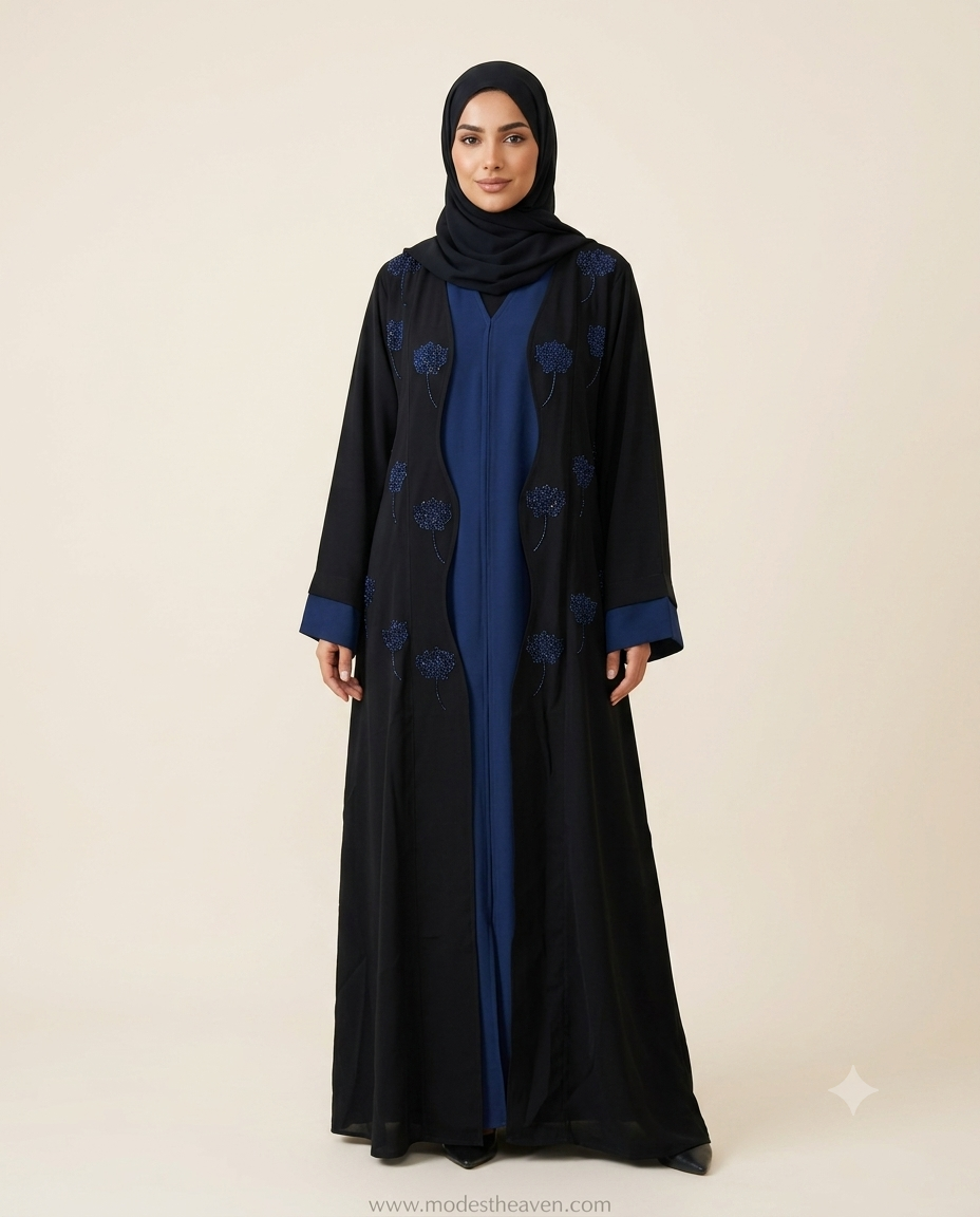 Woman wearing black open front abaya with royal blue floral sequin embroidery and blue inner lining with black hijab