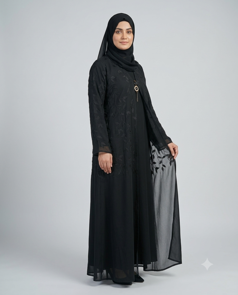 Woman wearing black sheer leaf embroidered layered abaya with pendant necklace and matching hijab, full-length side view