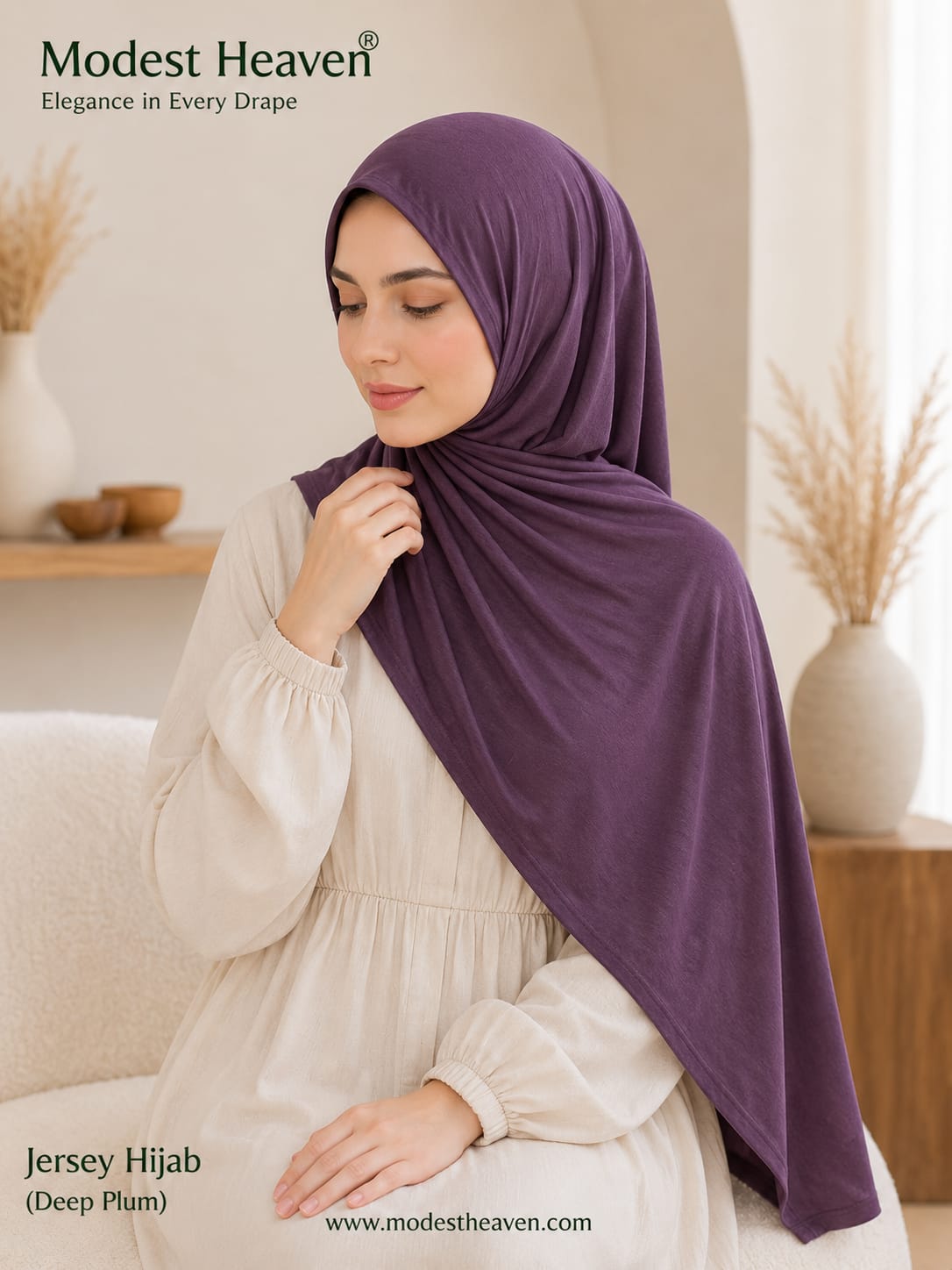 Woman wearing deep plum premium jersey hijab, seated portrait view