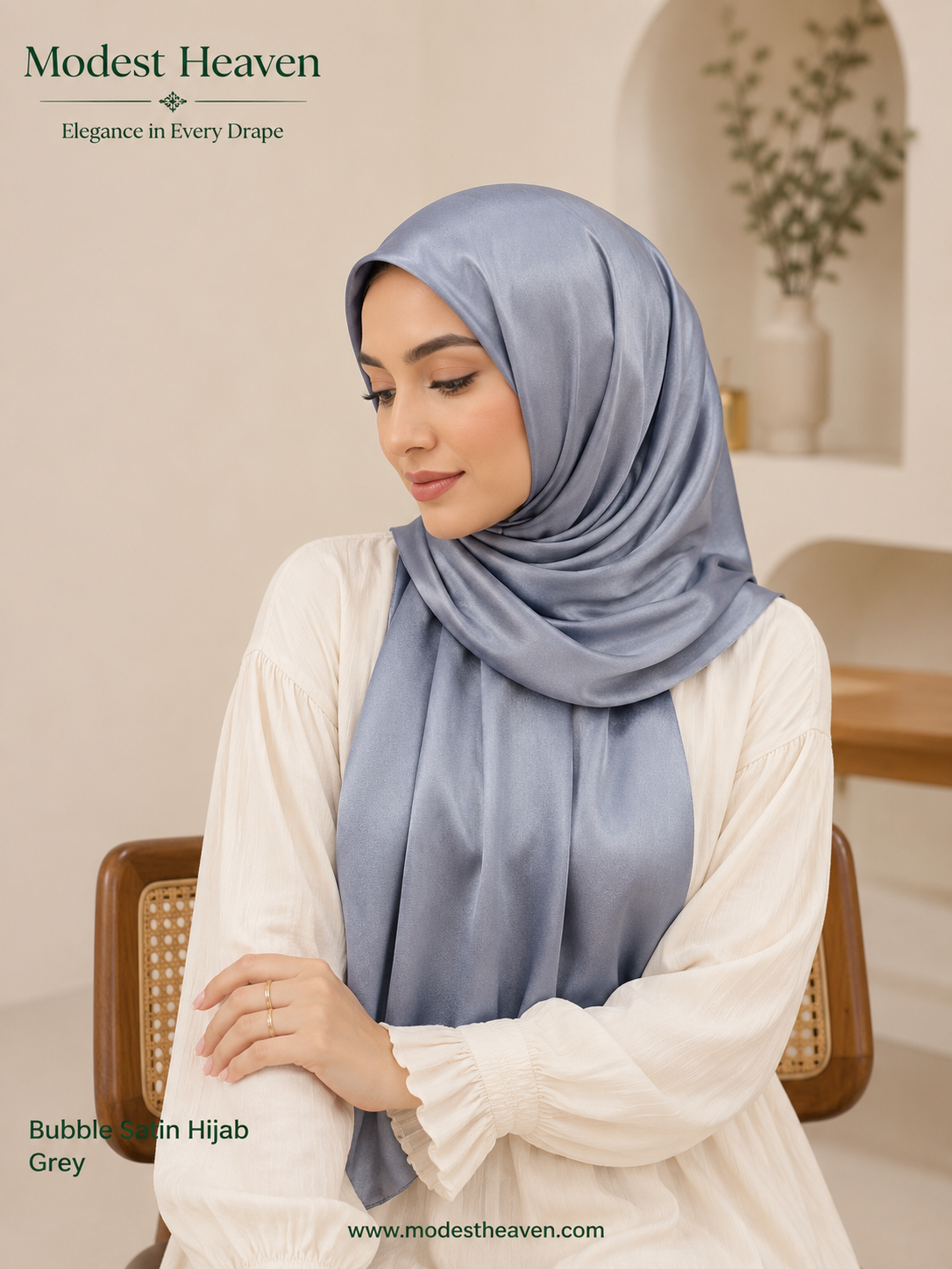 Woman wearing grey premium bubble satin hijab, seated portrait view