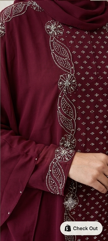 Close-up of pearl and stone embellishment detailing on maroon kaftan abaya front panel and cuff