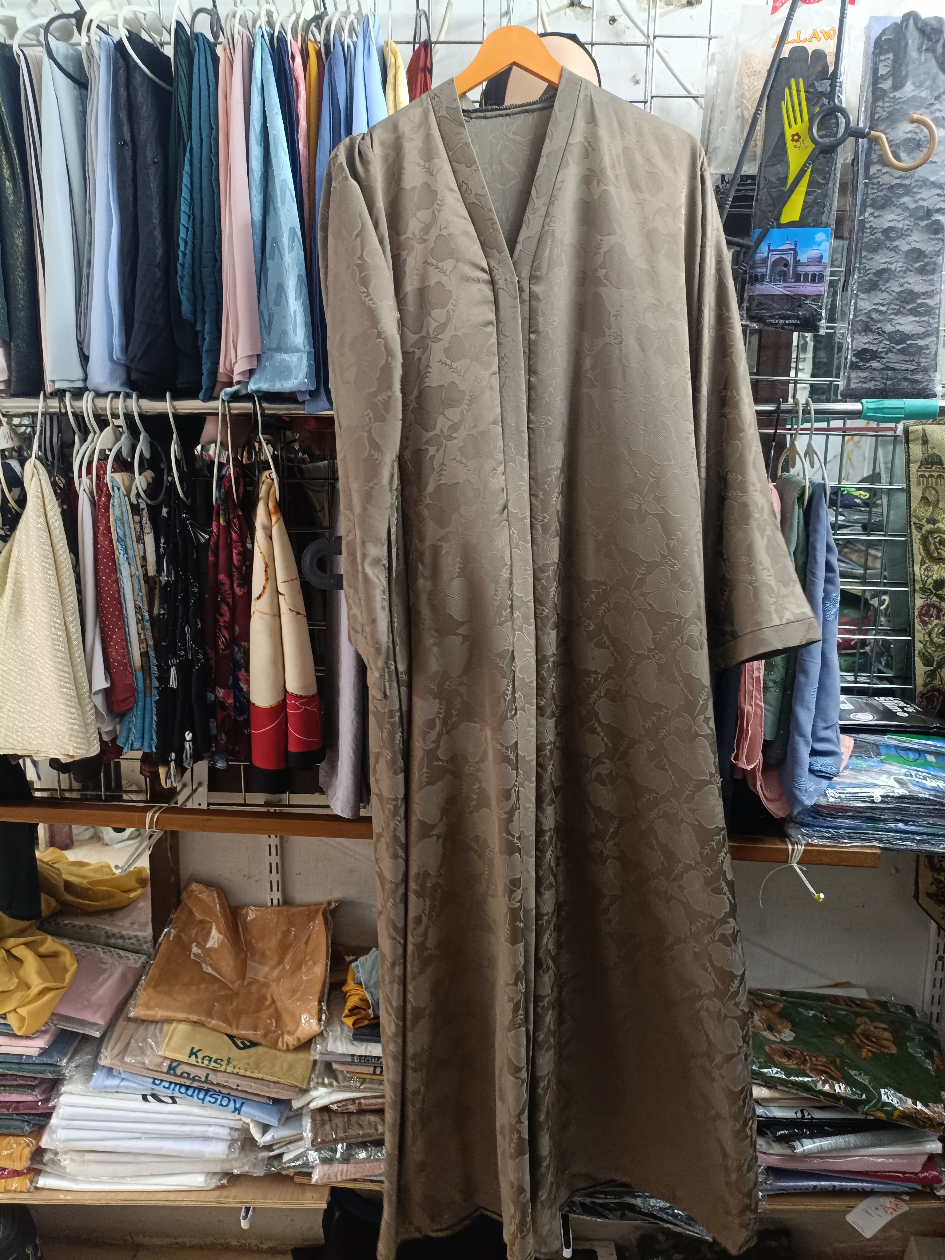 Woman wearing mocha brown jacquard floral texture closed abaya with matching hijab