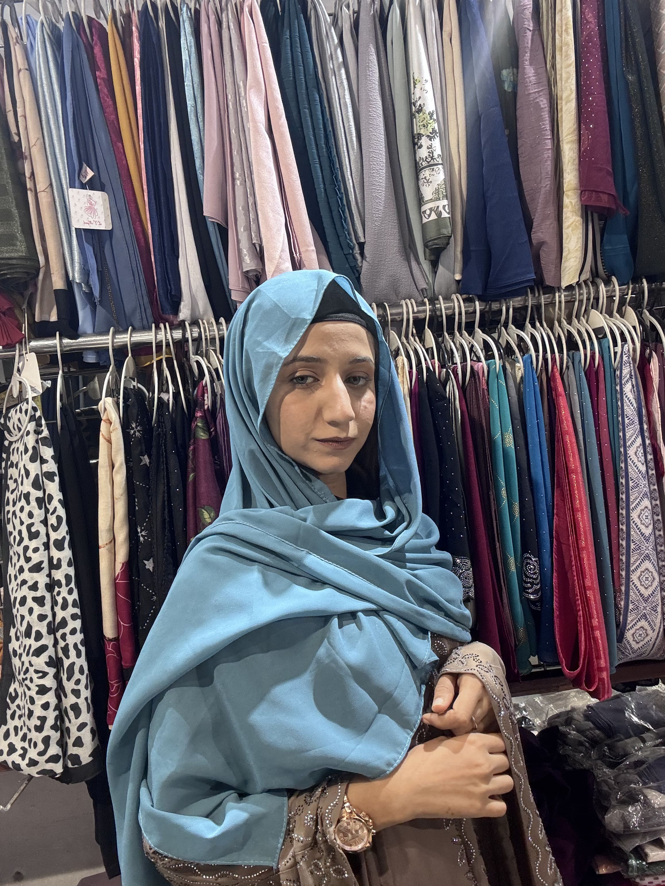 Woman wearing cerulean blue premium chiffon hijab scarf in clothing store