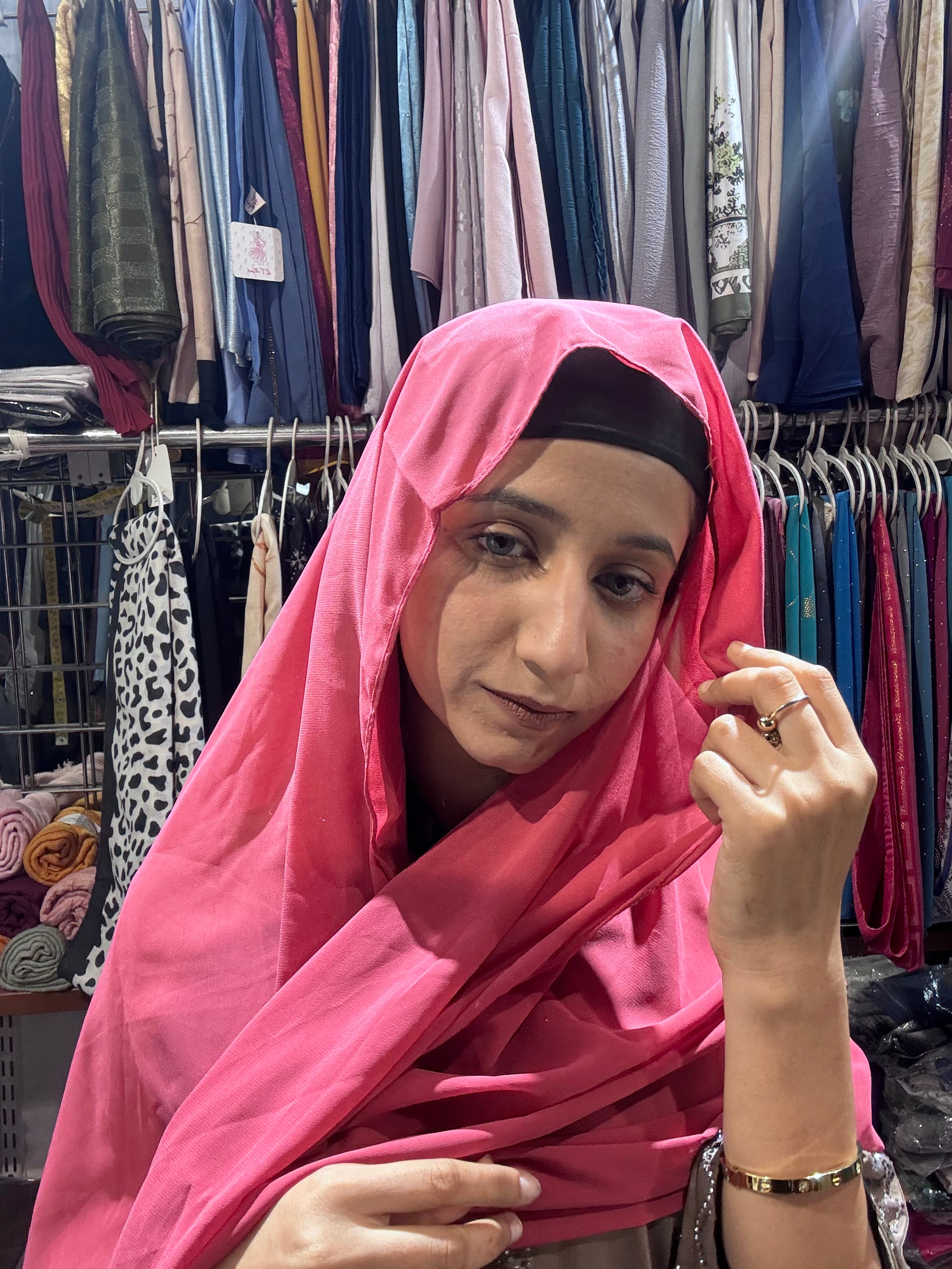 Woman wearing hot pink premium chiffon hijab scarf in clothing store