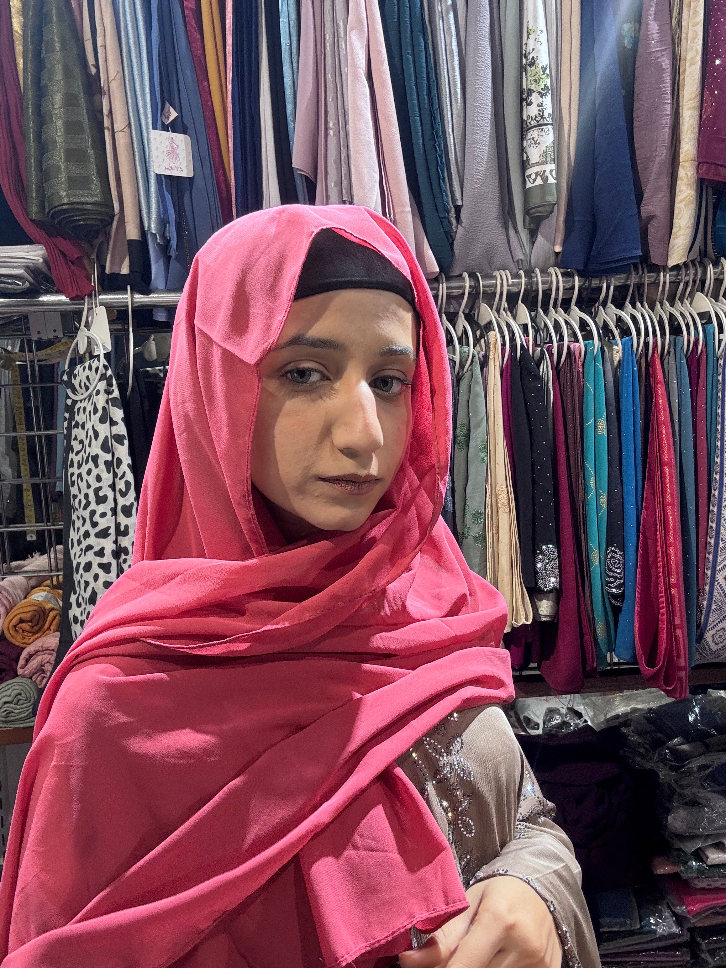Woman wearing hot pink premium chiffon hijab scarf in clothing store