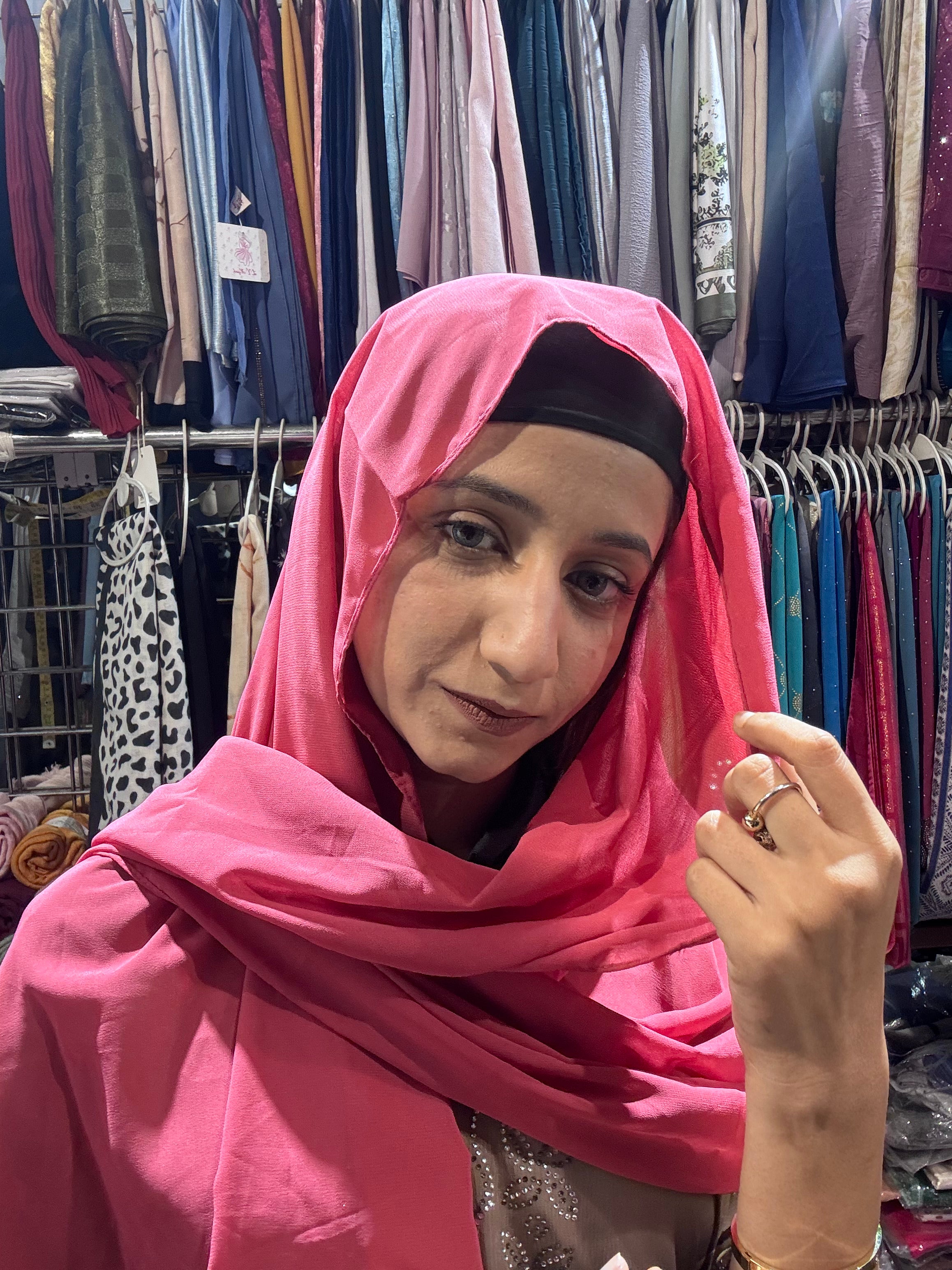 Woman wearing hot pink premium chiffon hijab scarf in clothing store