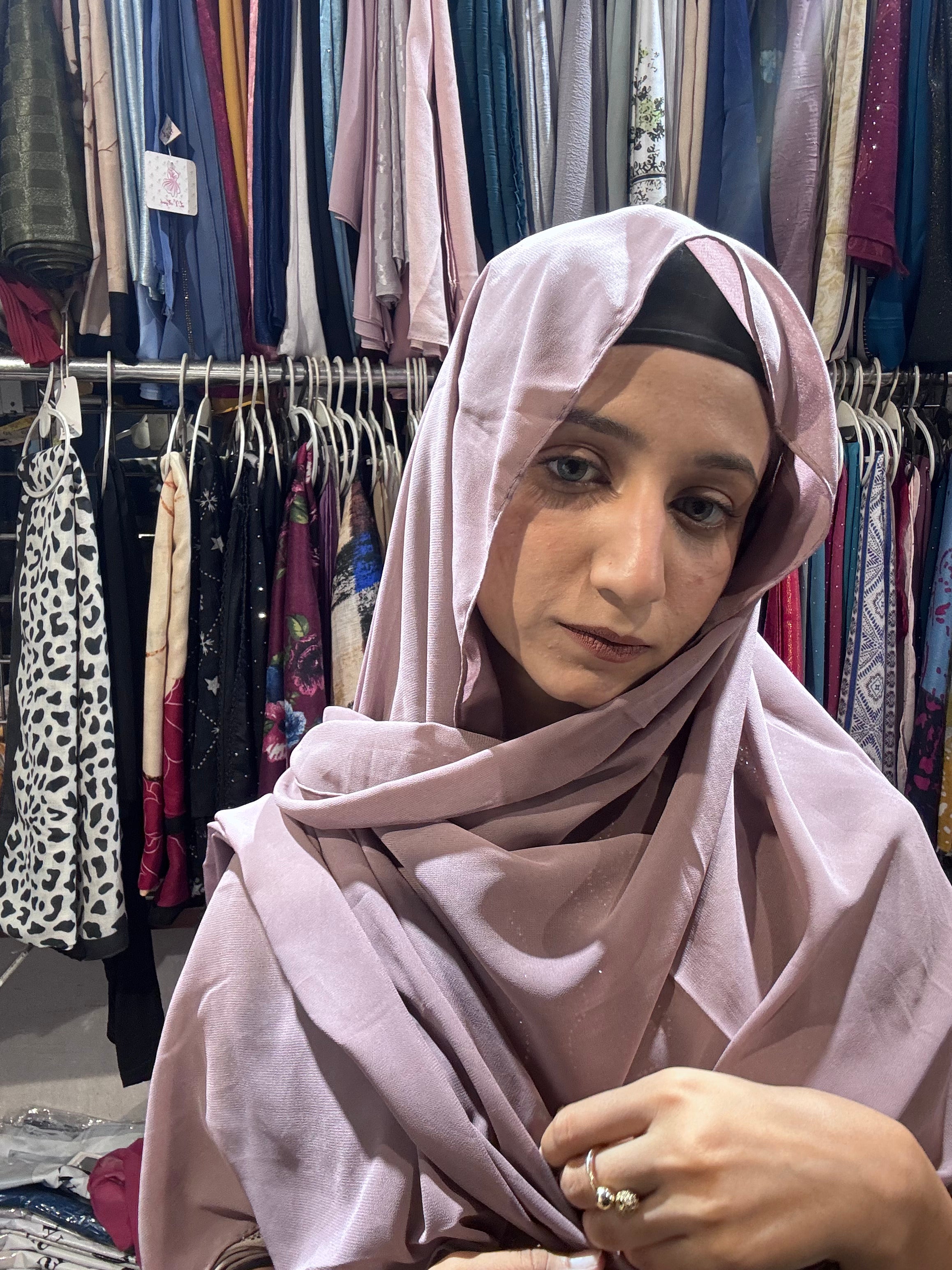 Woman wearing mauve pink premium chiffon hijab scarf in clothing store