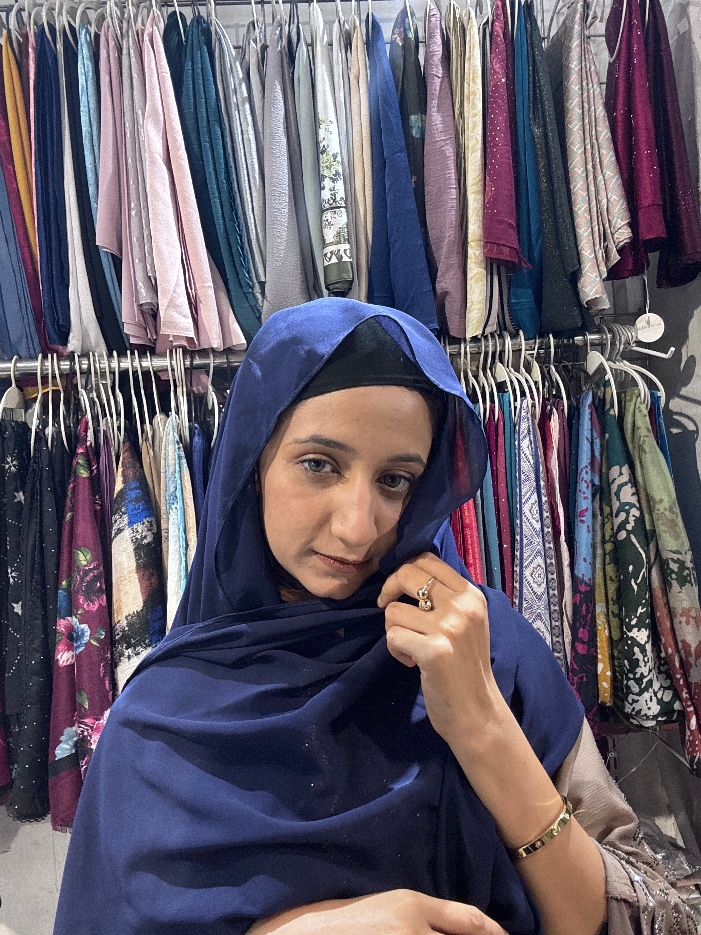 Close up of woman draping navy blue premium chiffon hijab scarf