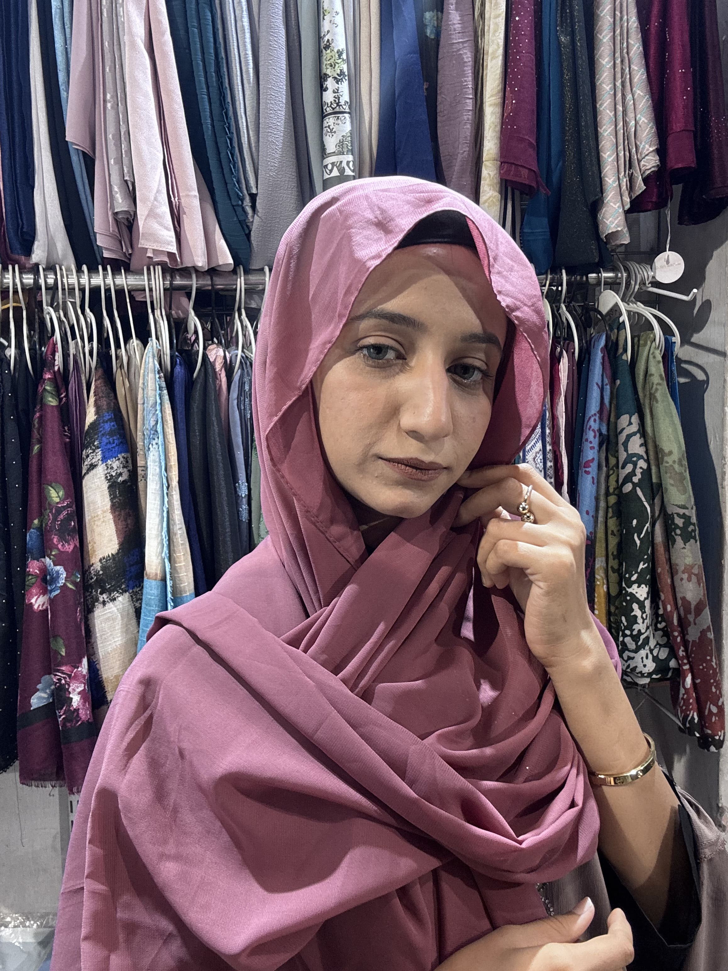 Woman wearing rose pink premium chiffon hijab scarf in clothing store