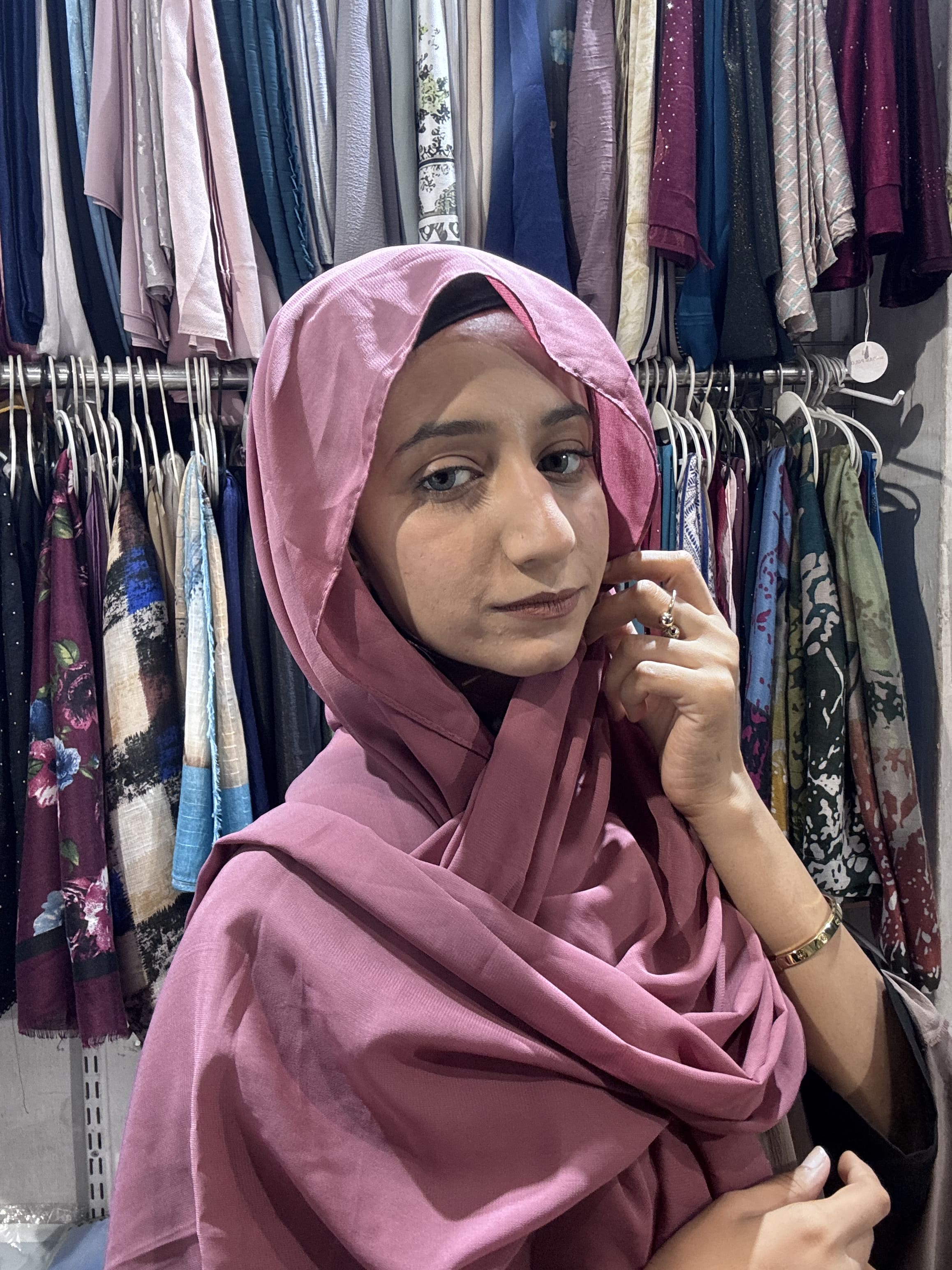 Woman wearing rose pink premium chiffon hijab scarf in clothing store