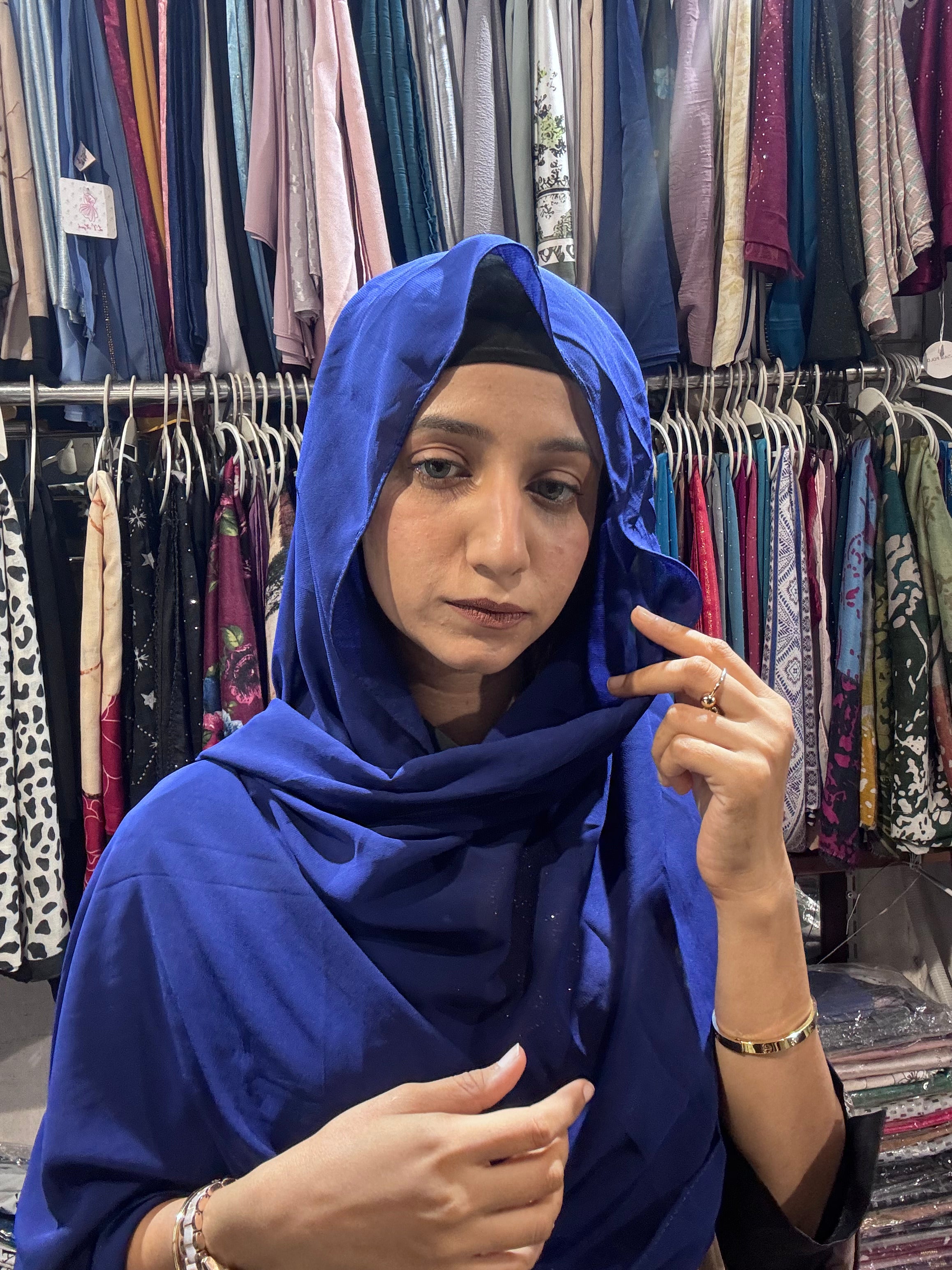 Woman wearing royal blue premium chiffon hijab scarf in clothing store