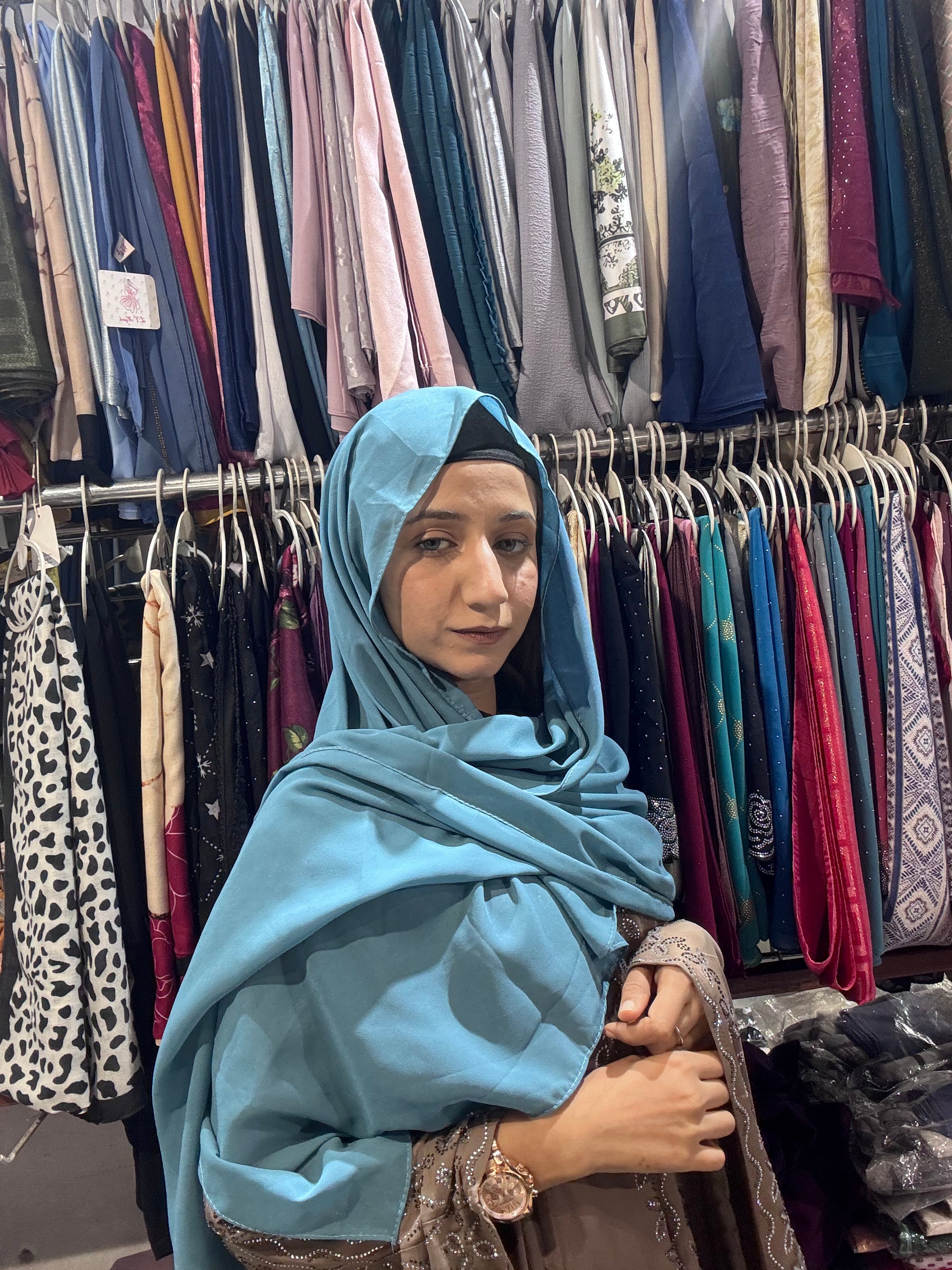 Woman wearing sky blue premium chiffon hijab scarf in clothing store