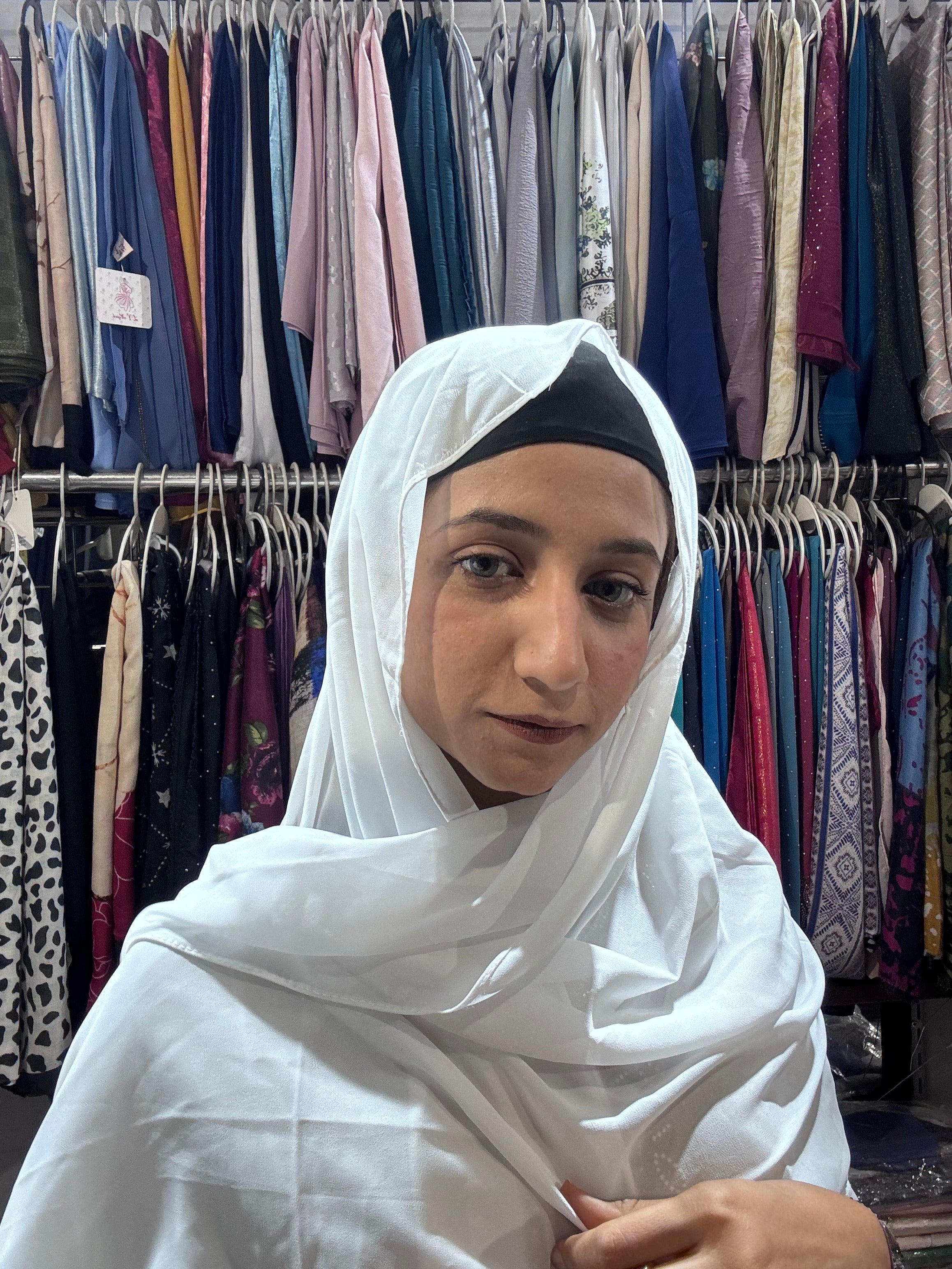 Woman wearing white premium chiffon hijab scarf in clothing store